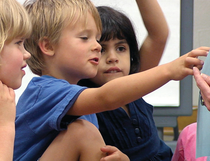 Two children are playing with a toy.