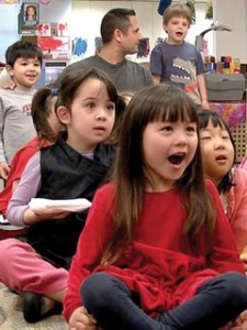 A group of children sitting in front of each other.