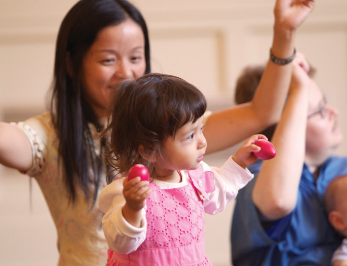 A woman and child playing wii with nintendo controllers.