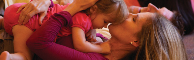 A woman and child laying on the ground.