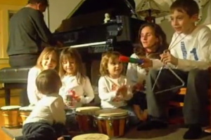 A group of children sitting around a piano