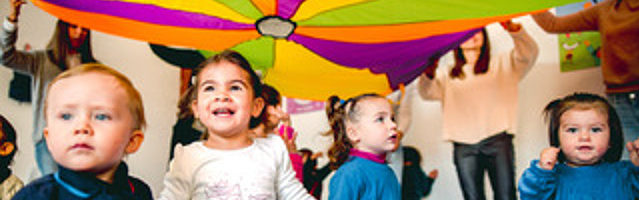 A group of children under an umbrella.